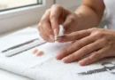 Mulher removendo unha postiça cuidadosamente para preservar as unhas naturais.