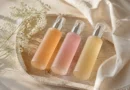 frascos de body mist em uma bandeja com flores e tecido claro