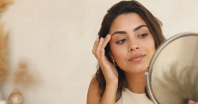 Mulher observando sobrancelhas recém-aplicadas em um espelho com expressão de dúvida