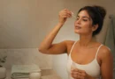 Mulher aplicando ácido glicólico no rosto durante rotina noturna de skincare