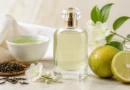 frasco de perfume sem marca ao lado de chá verde, folhas e flores claras em composição elegante