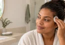 Mulher removendo suavemente uma pequena mancha de tinta de cabelo da pele com algodão.