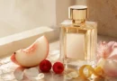 frasco de perfume sem marca entre pêssego, frutas vermelhas e flores em composição editorial