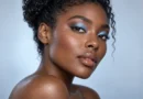 Mulher negra com sombra azul-gelo perolada e maquiagem luminosa