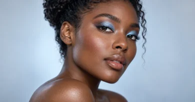 Mulher negra com sombra azul-gelo perolada e maquiagem luminosa